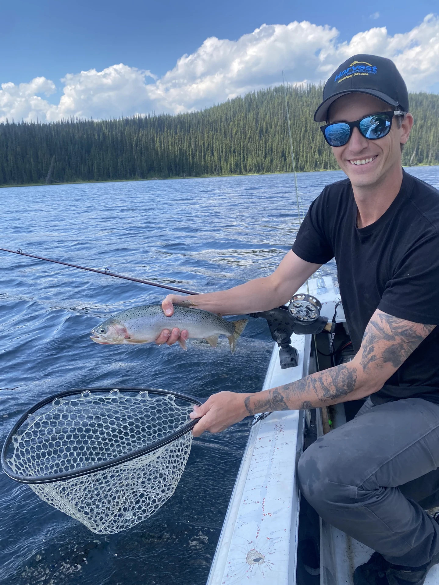David holding a fish beside the water from a boat